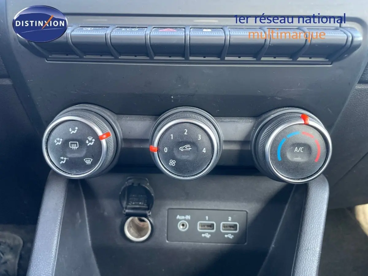 Gros plan sur les commandes de climatisation et les ports USB du tableau de bord intérieur d'une Renault Clio blanche de 2020.