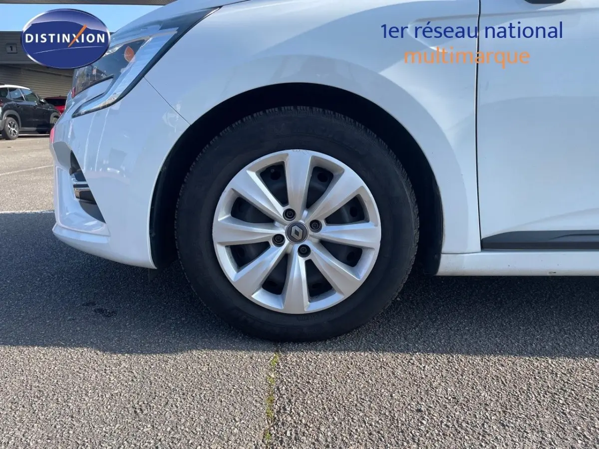 Gros plan sur la roue avant gauche d'une Renault Clio blanche 2020, avec jante alliage et logo Renault visible.