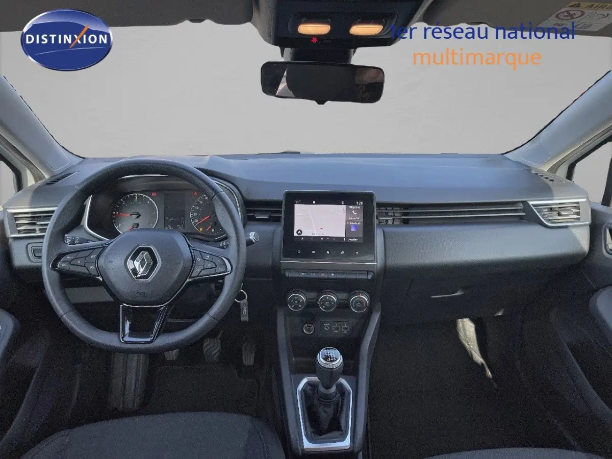 Tableau de bord et volant noir d'une Renault Clio 2020, vue frontale centrée sur l'écran tactile et la boîte manuelle.