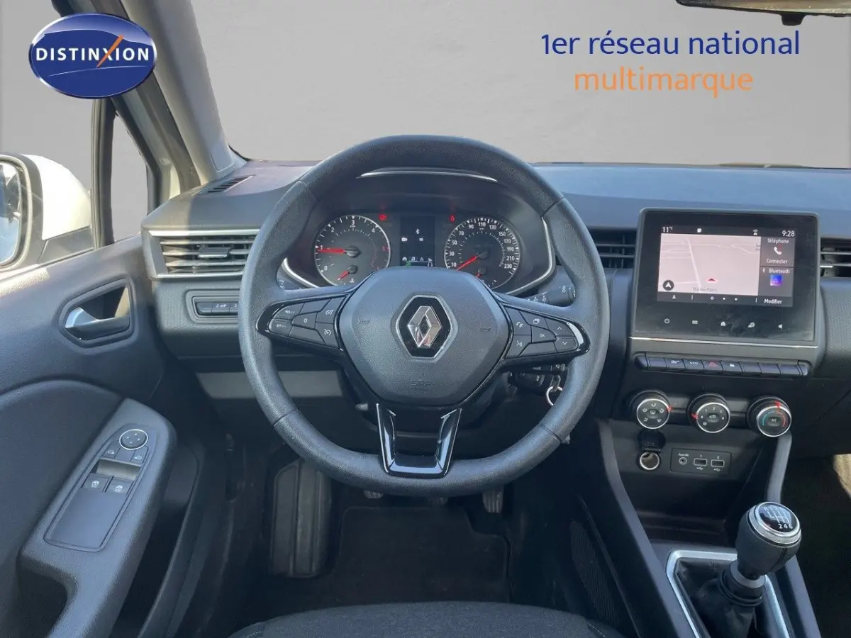Vue intérieure avant centrée sur le volant multifonctions et tableau de bord avec écran tactile de la Renault Clio blanche 2020.