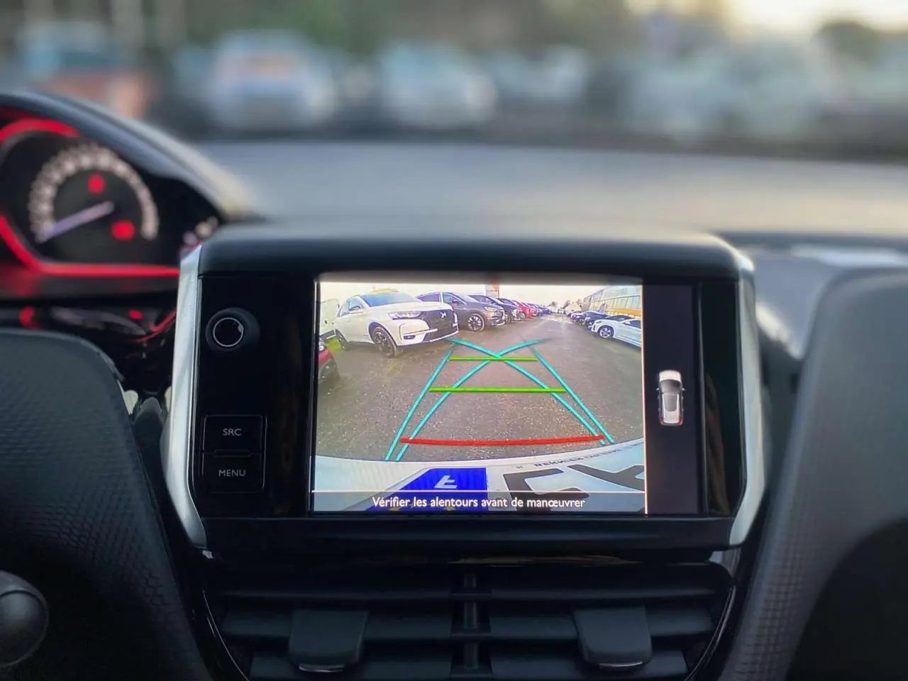 Écran de caméra de recul dans Peugeot 2008 blanc 2016 GT Line, vue intérieure du tableau de bord avec guidage de trajectoire.