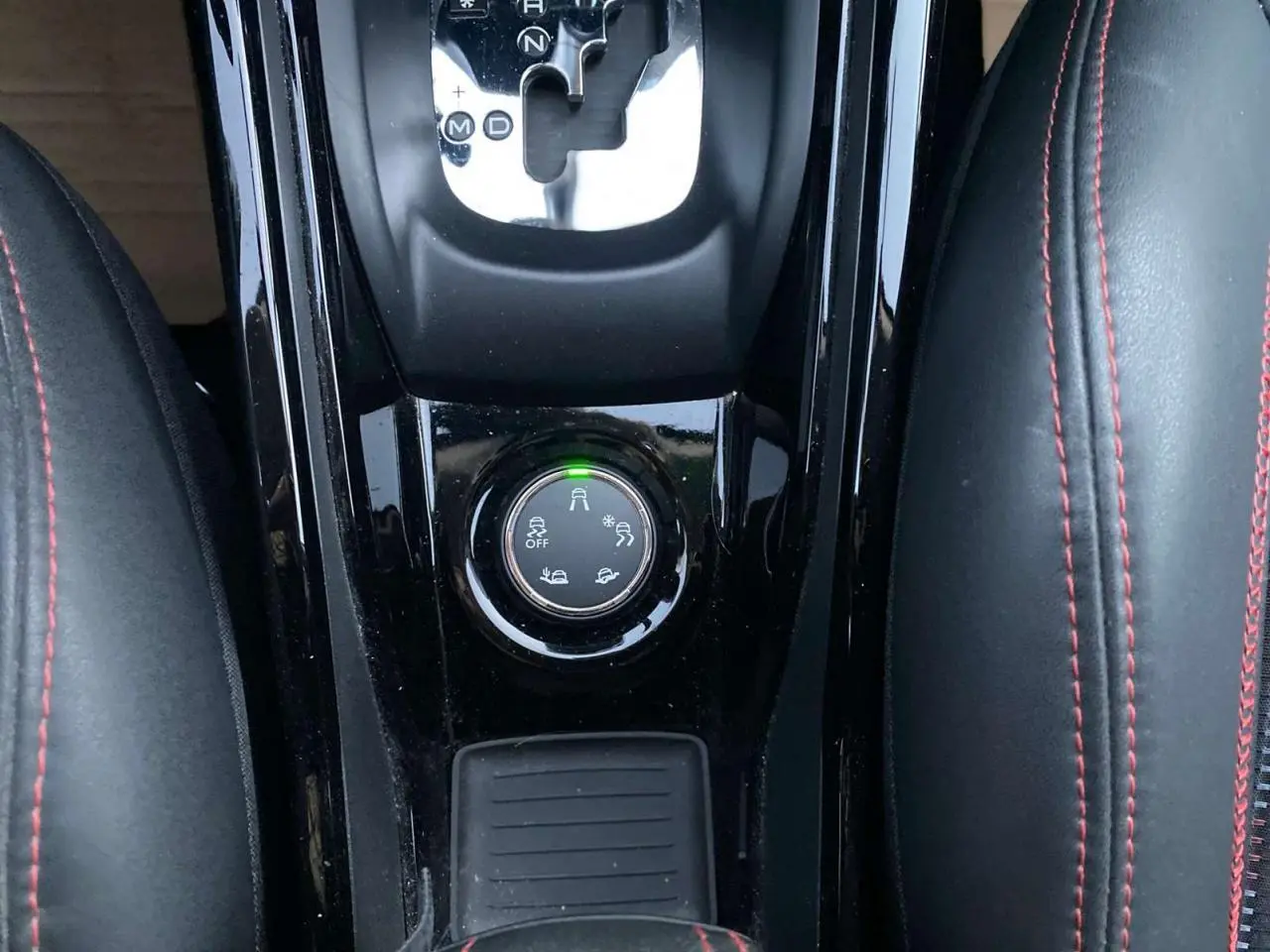 Gros plan sur la console centrale noire du Peugeot 2008 blanc 2016, avec levier de boîte auto et bouton de modes de conduite.
