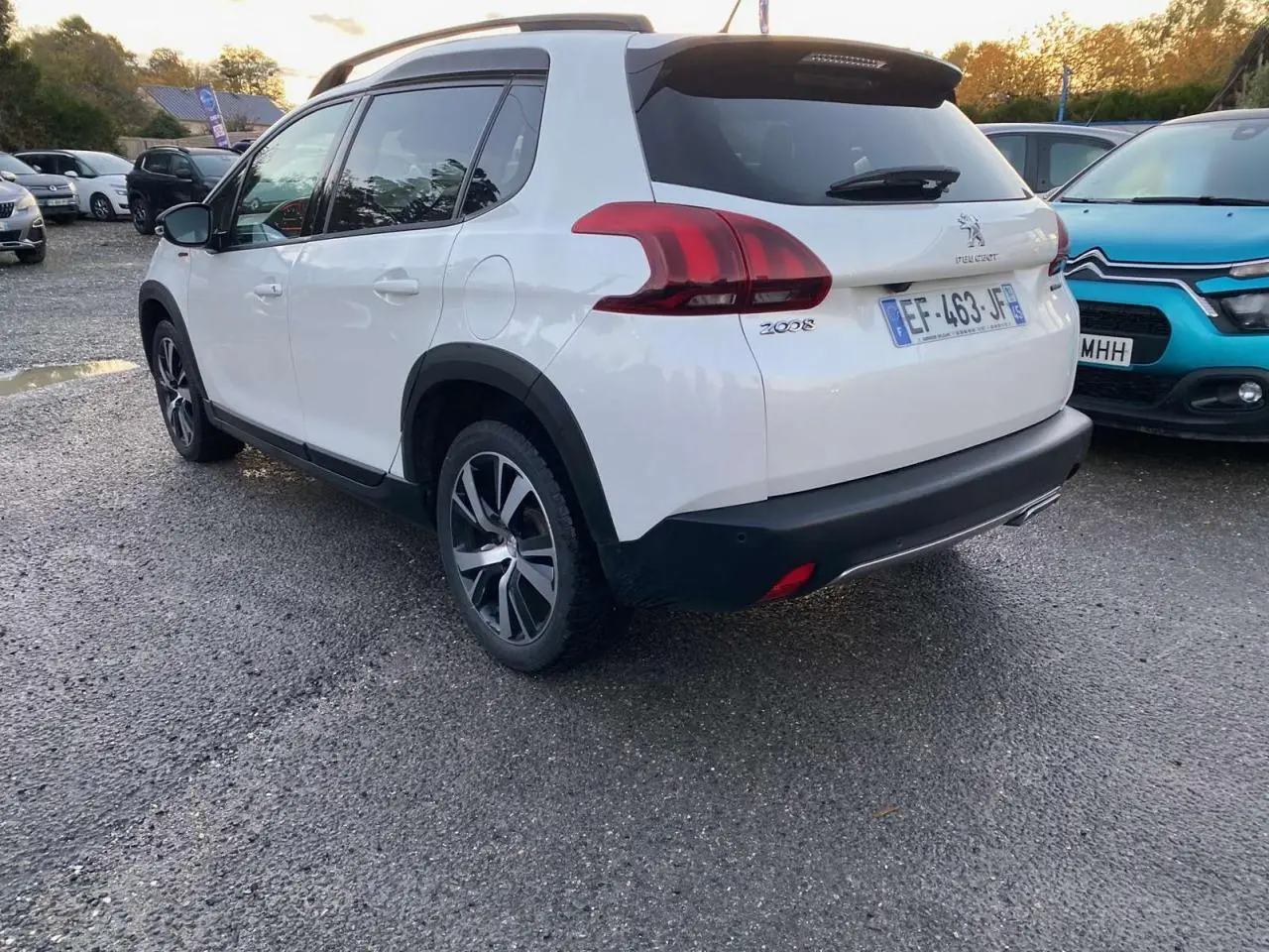 Peugeot 2008 blanc en 3/4 arrière droit, avec jantes alliage et détails noirs contrastants visibles.