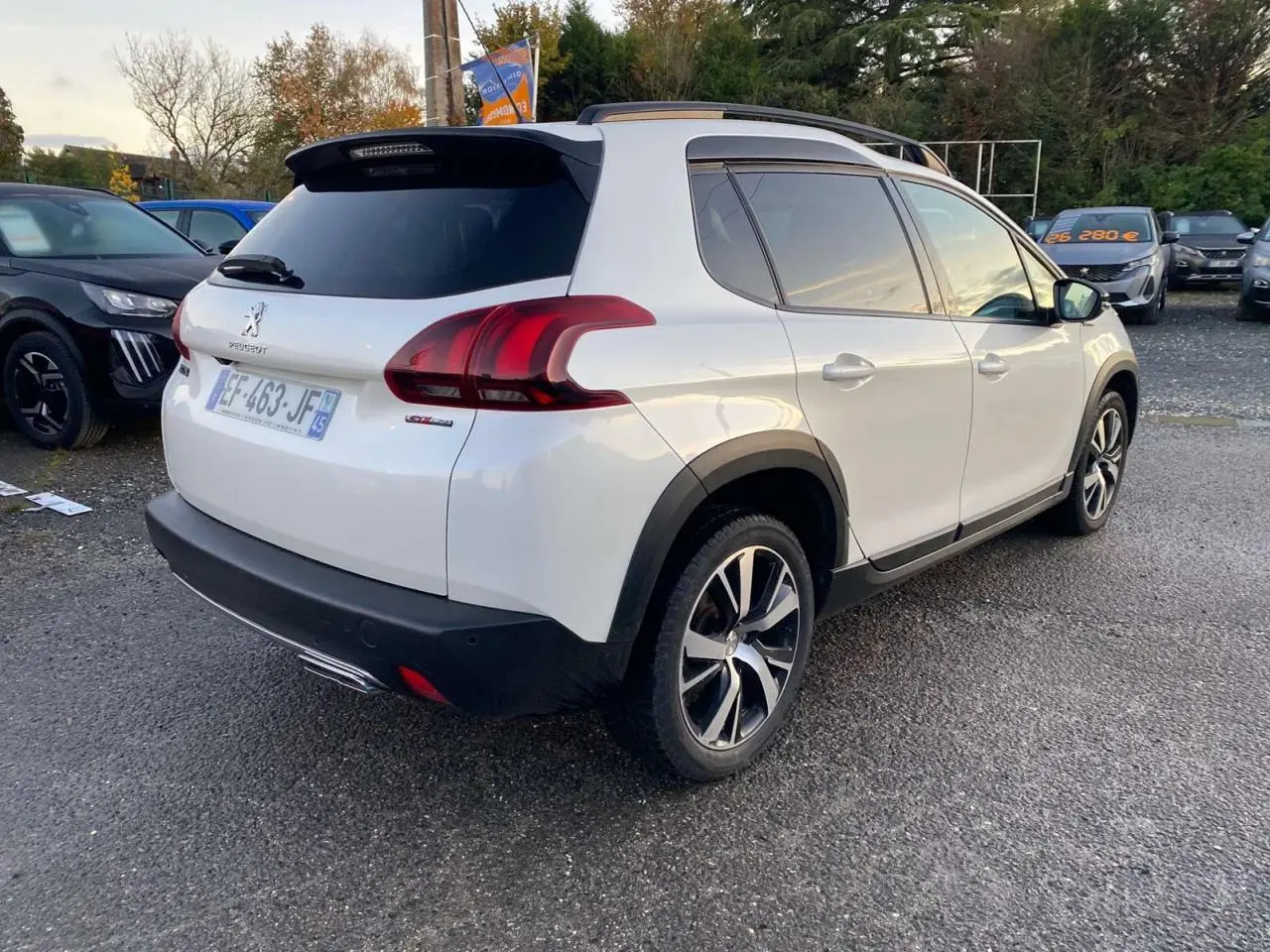Peugeot 2008 blanc en 3/4 arrière droit, version GT Line avec jantes alliage et toit panoramique visible.
