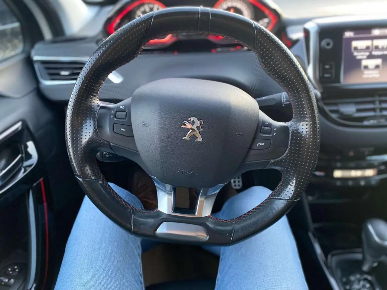 Vue rapprochée du volant en cuir perforé du Peugeot 2008 blanc 2016 GT Line avec commandes intégrées.