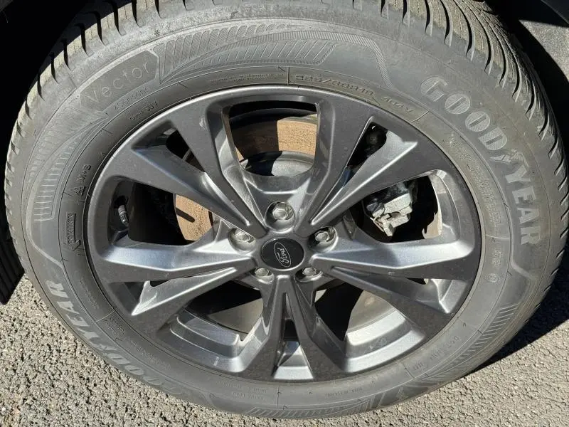 Gros plan sur la jante alliage gris foncé et pneu Goodyear du Ford Kuga noir Agate Métallisée 2024.