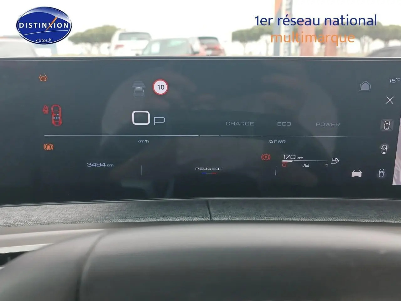 Tableau de bord numérique du Peugeot 3008 gris Artense, affichant la vitesse, autonomie et alertes, vue de face depuis le siège conducteur.