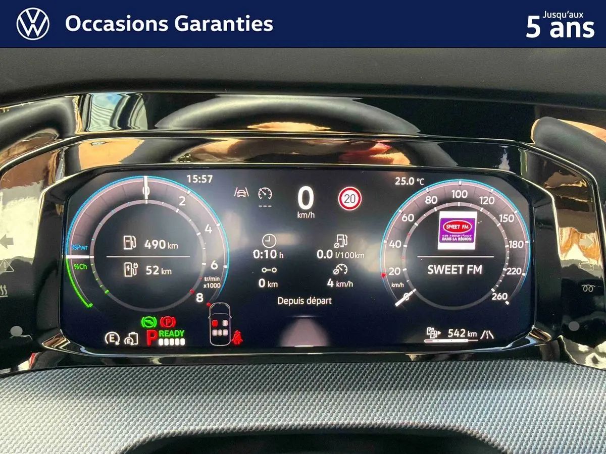 Tableau de bord digital de la Volkswagen Golf 1.5 eHybrid 272 DSG6 2025 affichant vitesse, autonomie et radio Sweet FM.