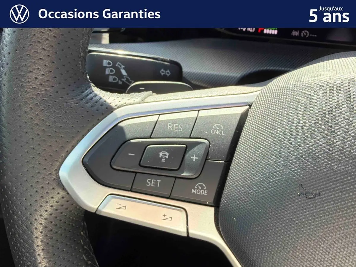 Gros plan sur le volant sport multifonction en cuir de la Volkswagen Golf 1.5 eHybrid 2025, avec commandes intégrées.