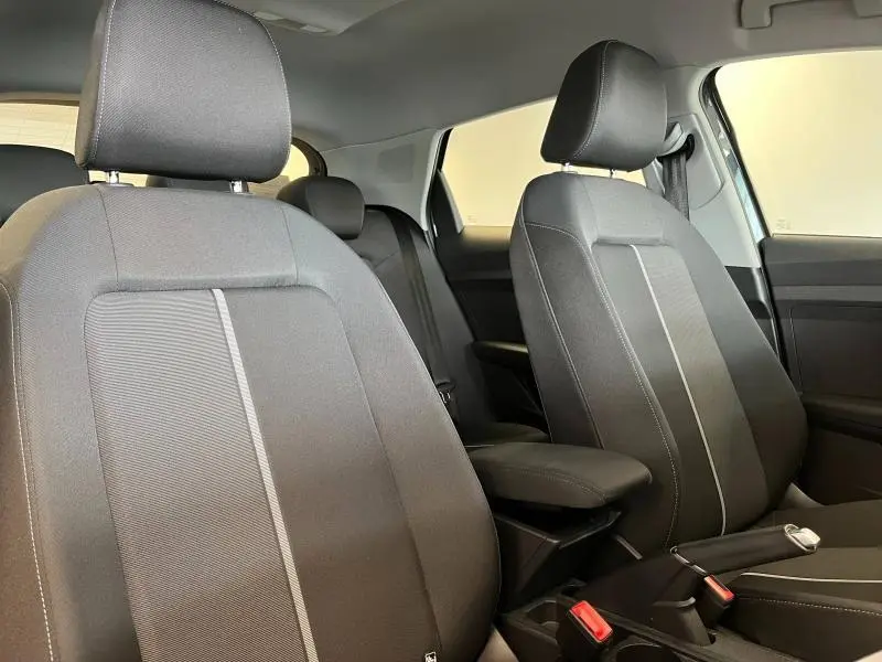 Vue intérieure de l'Audi A1 Sportback 2020 montrant les sièges avant en tissu noir avec accoudoir central.