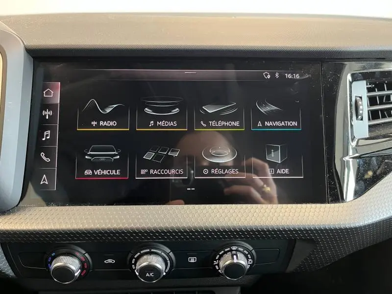 Écran tactile central de l'Audi A1 Sportback 2020 affichant le menu multimédia avec commandes climatisation en dessous.