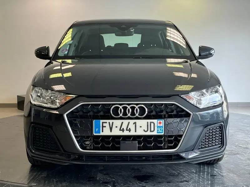 Vue frontale d'une Audi A1 Sportback 25 TFSI noire Mythic métallisé avec calandre hexagonale et phares halogènes.