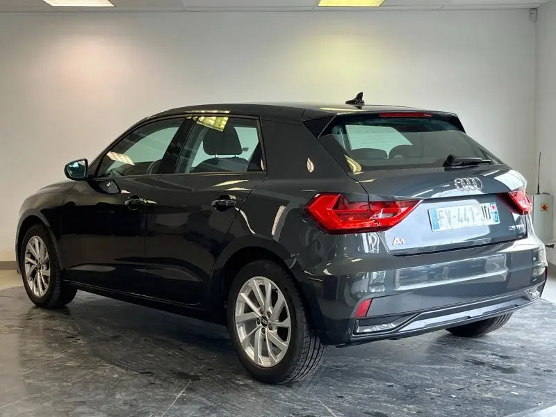 Audi A1 Sportback noir Mythic métallisé vue 3/4 arrière droit avec feux LED et jantes alu dans un garage.