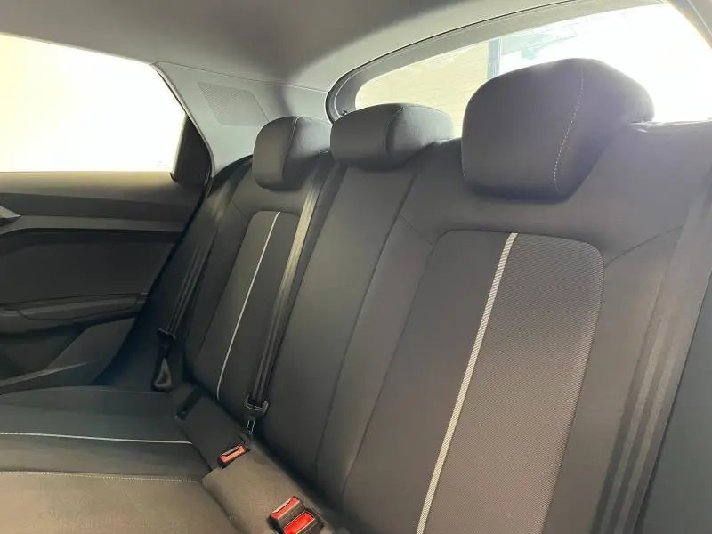 Vue intérieure des sièges arrière noirs avec surpiqûres claires de l'Audi A1 Sportback 2020 en tissu Debut Noir