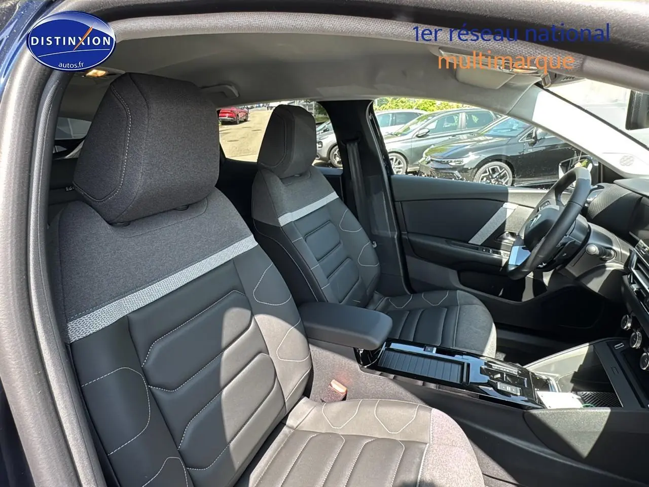 Intérieur de la Citroën C4 1.5 BlueHDi 130, vue côté gauche, sièges bi-matière gris et noir avec accoudoir central.