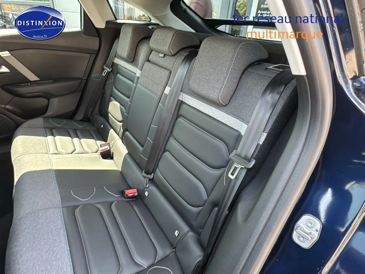 Vue côté droit sur la banquette arrière bicolore cuir et tissu du Citroën C4 bleu eclipse avec ceinture de sécurité visible.