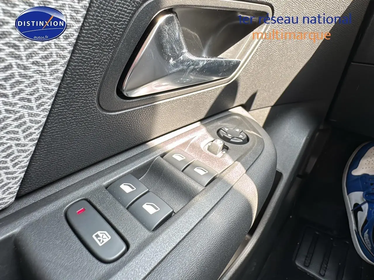 Gros plan sur les commandes des vitres et rétroviseurs côté conducteur d'une Citroën C4 1.5 BlueHDi 130 bleu Eclipse.