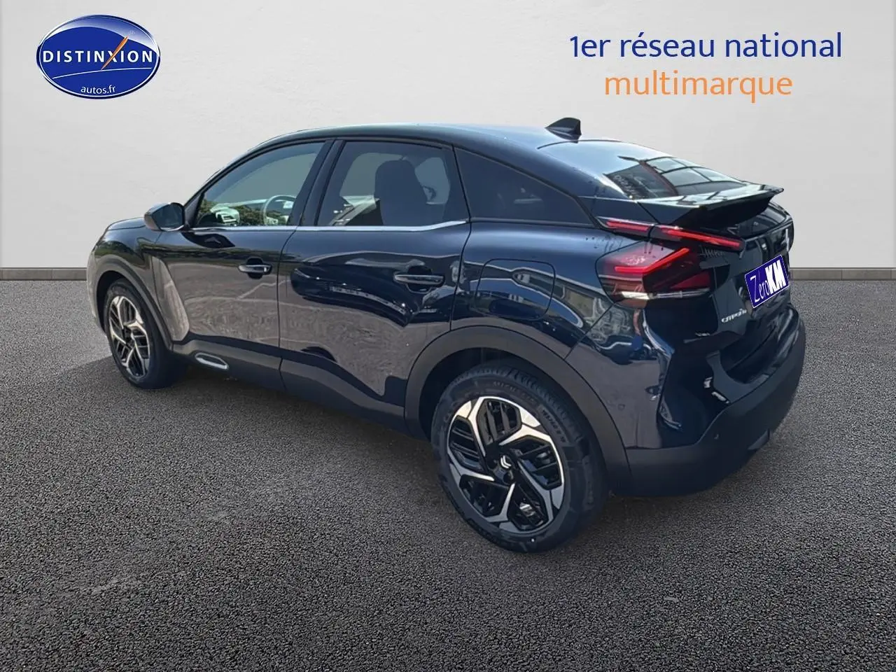 Vue 3/4 arrière droite d'une Citroën C4 2025 bleu eclipse avec jantes alu et vitres surteintées.