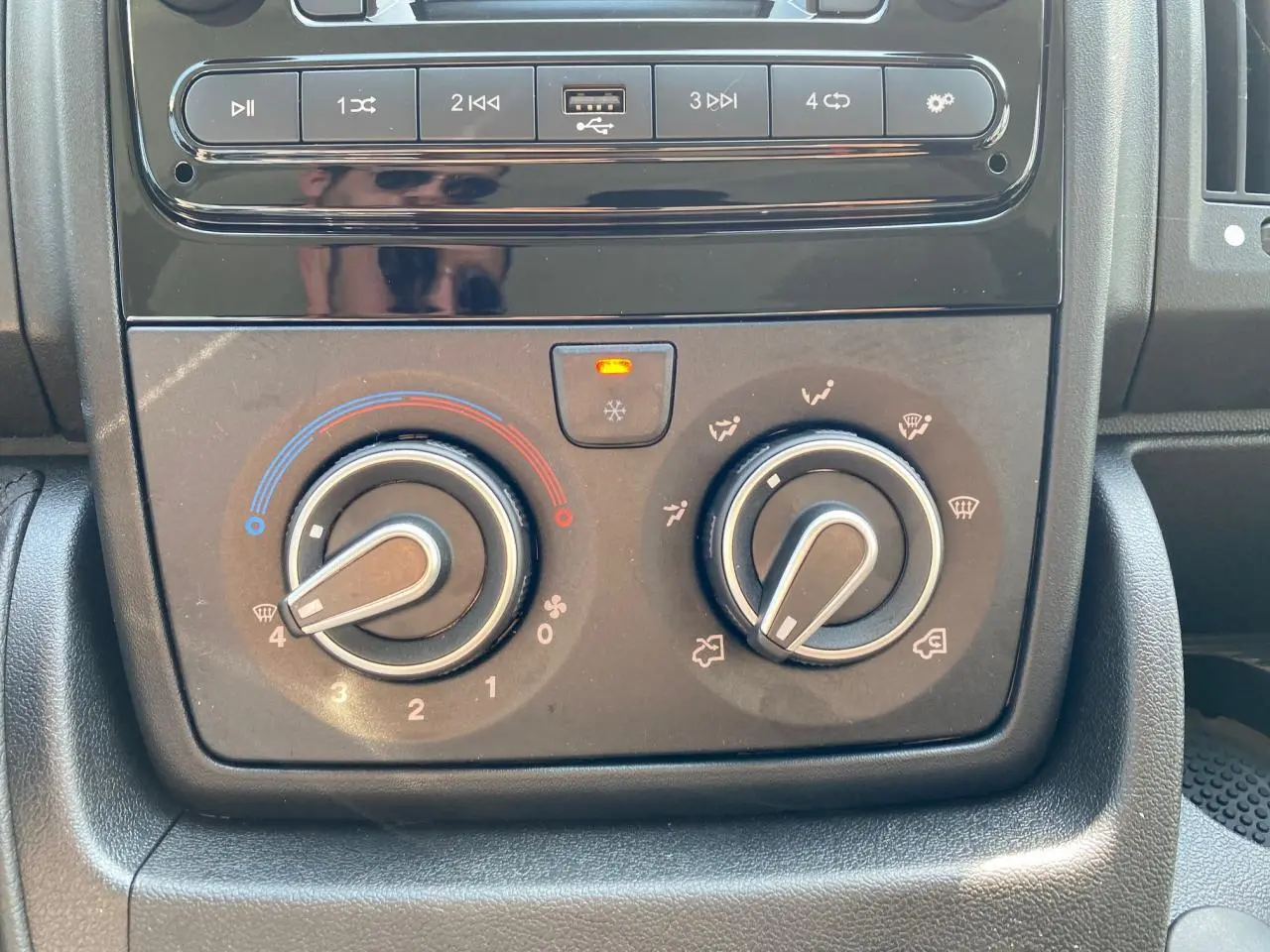 Tableau de bord du Citroën Jumper 2023 avec commandes manuelles de climatisation et lecteur multimédia noir.