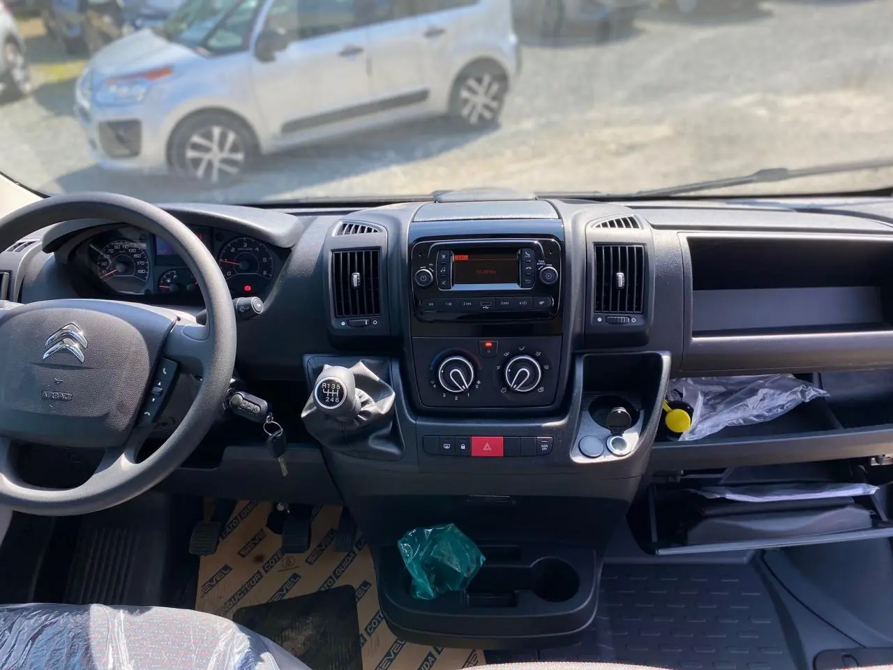 Vue intérieure du tableau de bord du Citroën Jumper blanc 2023 avec volant, boîte manuelle et commandes centrales visibles.