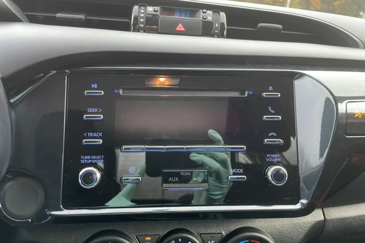 Vue rapprochée de la console centrale du Toyota Hilux 4x4 2024, mettant en valeur l'écran tactile et les commandes audio.