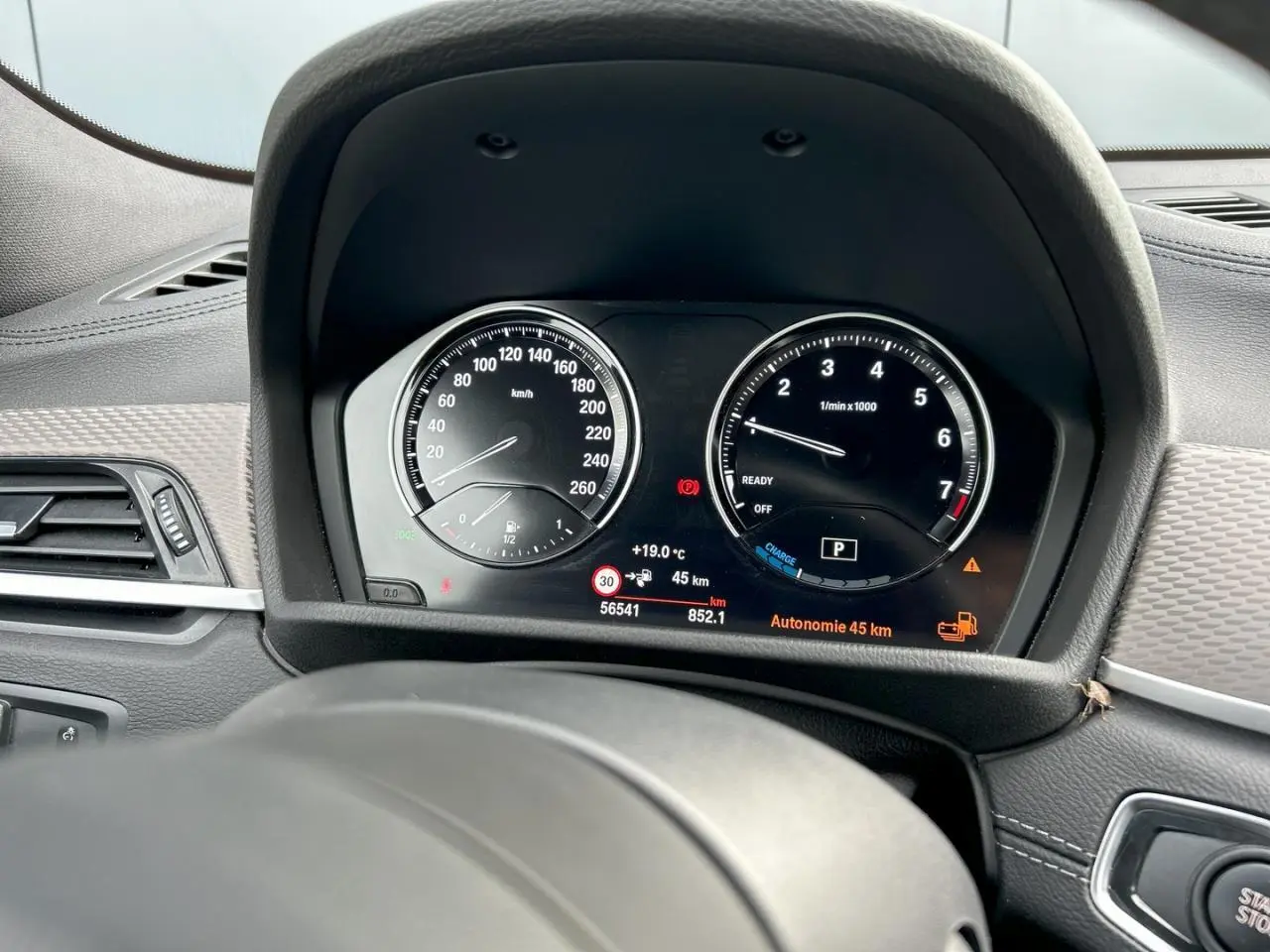 Tableau de bord et compteur digital de BMW X2 F39, affichant 45 km d'autonomie, intérieur noir et détails gris.