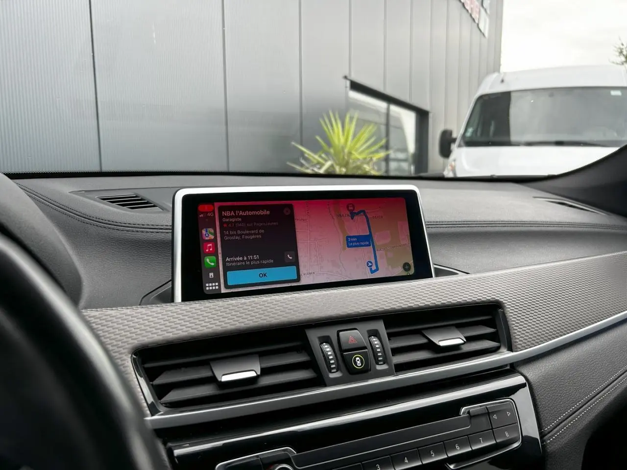 Tableau de bord de BMW X2 F39 2021 avec écran GPS tactile affichant un itinéraire, ambiance intérieure moderne.