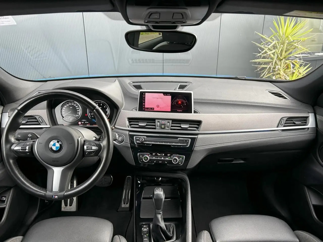 Vue intérieure avant du BMW X2 F39 M Sport 2021, tableau de bord noir avec écran GPS et volant cuir M.