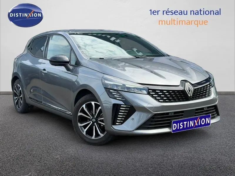 Renault Clio 2025 gris schiste vue 3/4 avant droit avec calandre noire et jantes alliage bicolores.