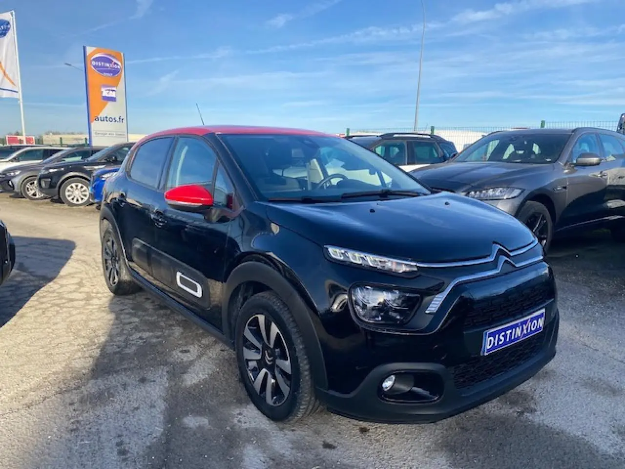 Citroën C3 Shine 2023 vue 3/4 avant en noir avec toit et rétroviseurs rouges, jantes alliage diamantées.