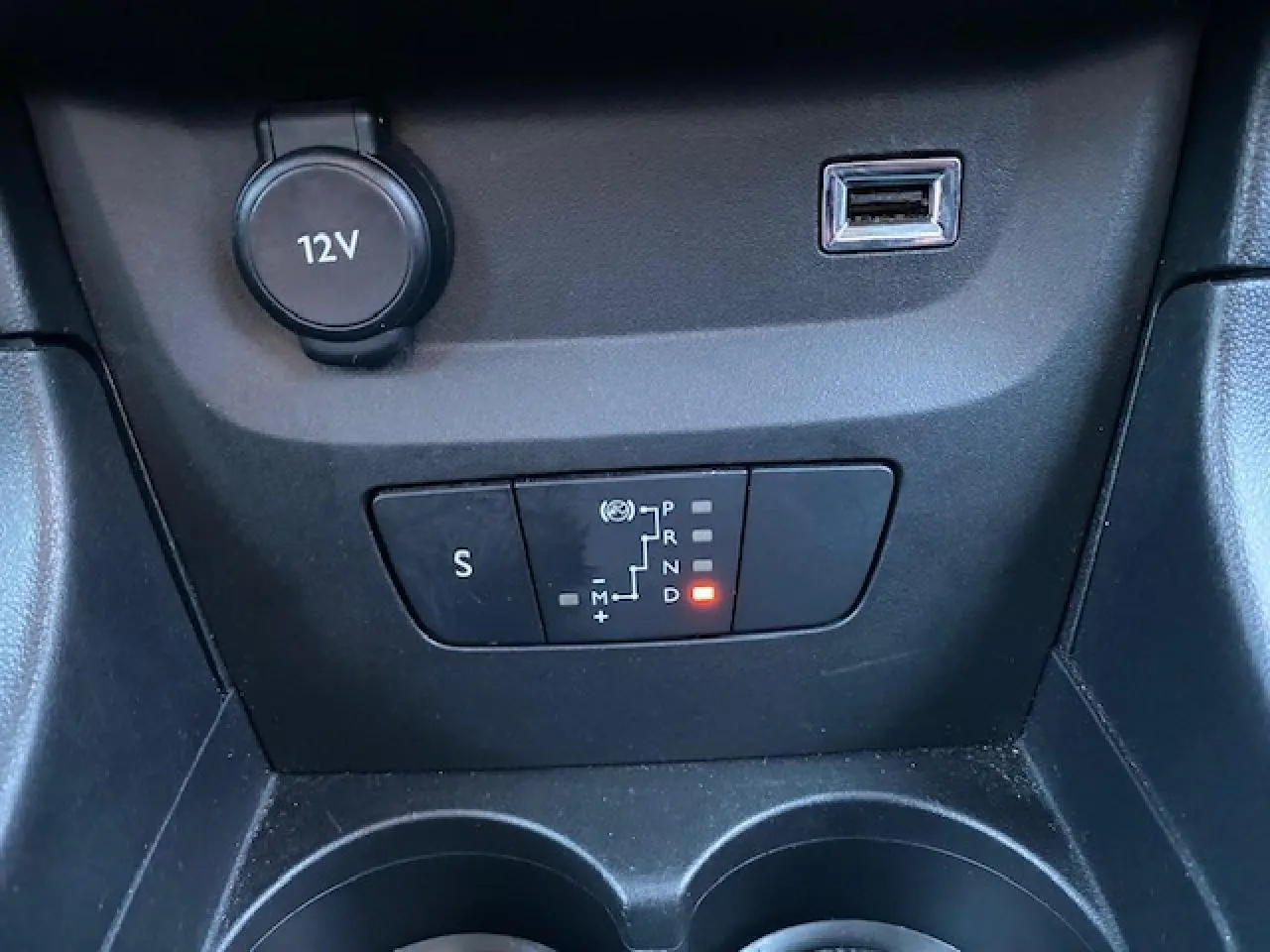 Gros plan sur la commande de boîte automatique et prise USB dans l'habitacle noir de la Citroën C3 Shine 2023.