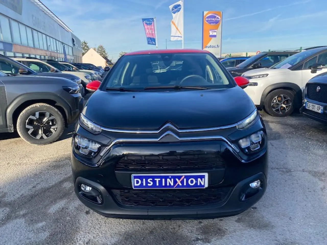 Citroën C3 Shine 2023 noir avec toit rouge, vue de face mettant en valeur les phares LED et la calandre distinctive.