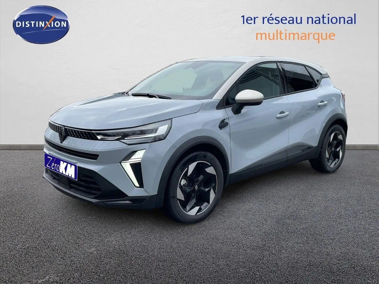 Renault Captur 2025 gris Rafale métal avec toit beige, vue 3/4 avant droit mettant en valeur ses jantes noires stylisées.