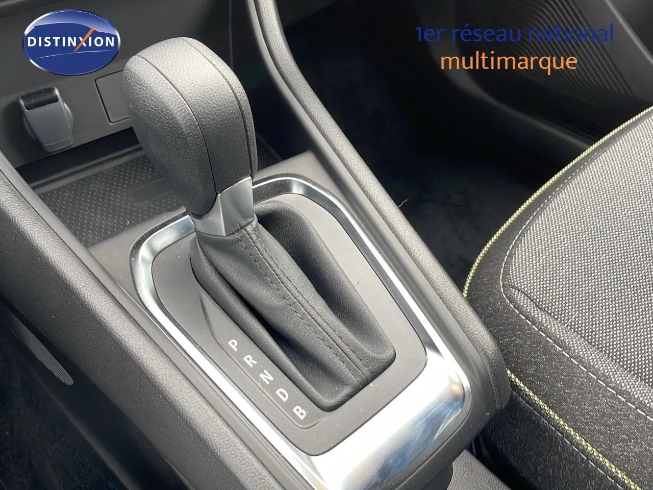 Le levier de vitesse automatique en cuir noir du Renault Captur 2025, avec couture jaune visible sur la sellerie tissu.