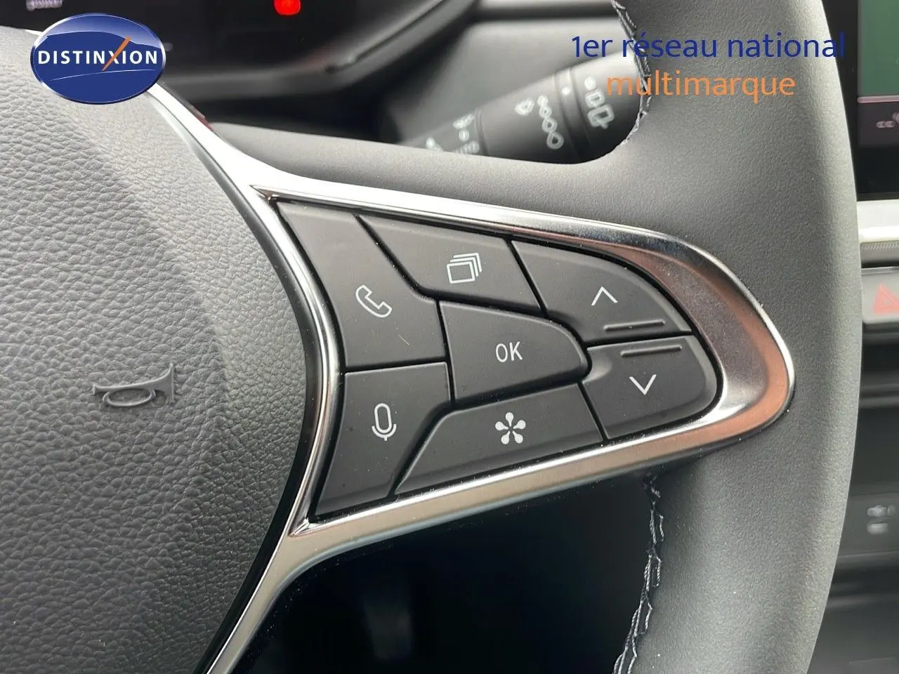 Gros plan sur les commandes multifonctions à droite du volant du Renault Captur gris Rafale métal avec toit beige.