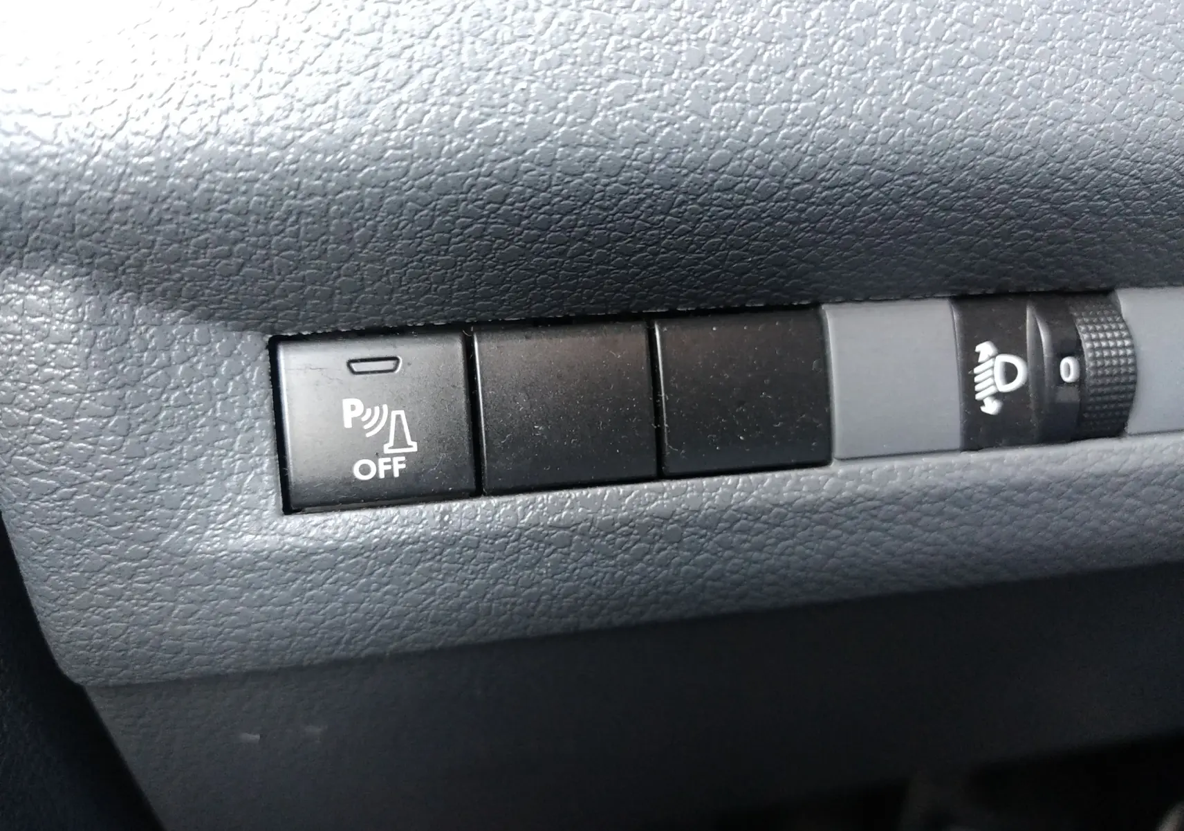 Gros plan sur les boutons de commande du tableau de bord du Citroën Jumpy blanc, avec bouton de désactivation du radar de recul.