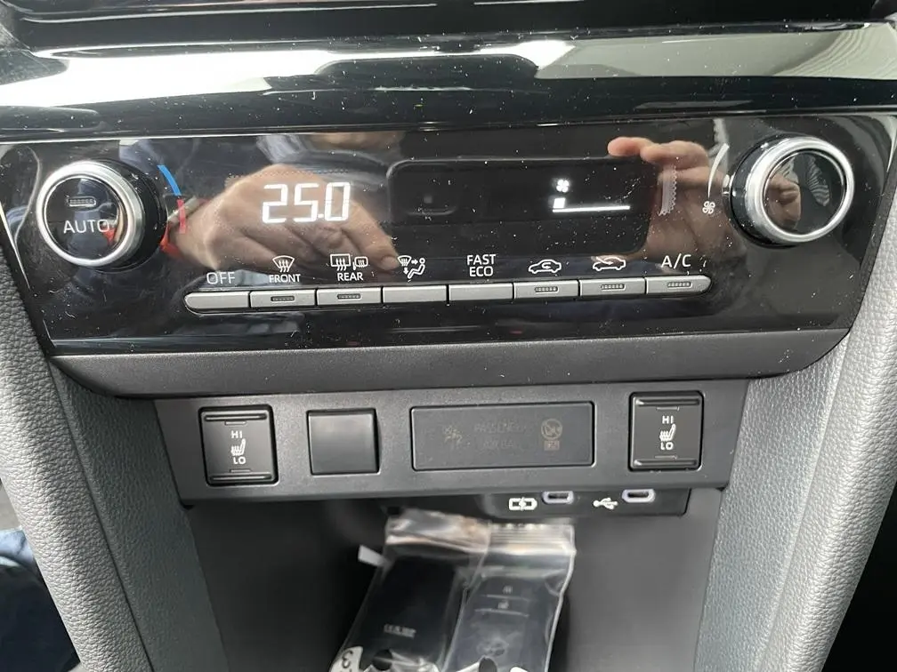 Détail de la console centrale noire de la Toyota Yaris Cross 2026, affichage digital de la climatisation à 25°C.