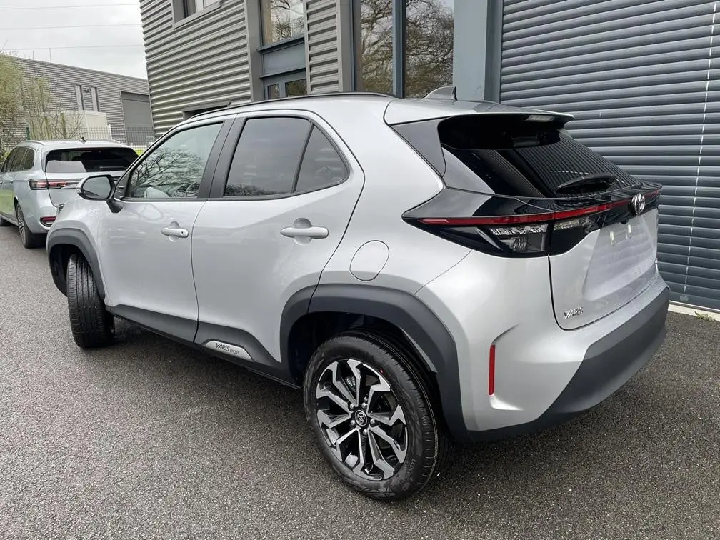 Toyota Yaris Cross gris clair vue 3/4 arrière droit, avec jantes alliage et feux arrière LED noirs.