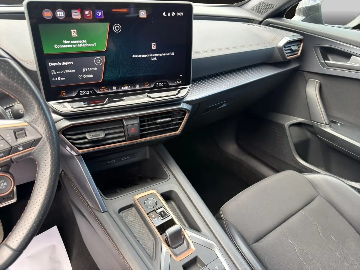 Intérieur avant droit de la CUPRA Formentor 2025, tableau de bord noir avec écran tactile central et volant cuir perforé.