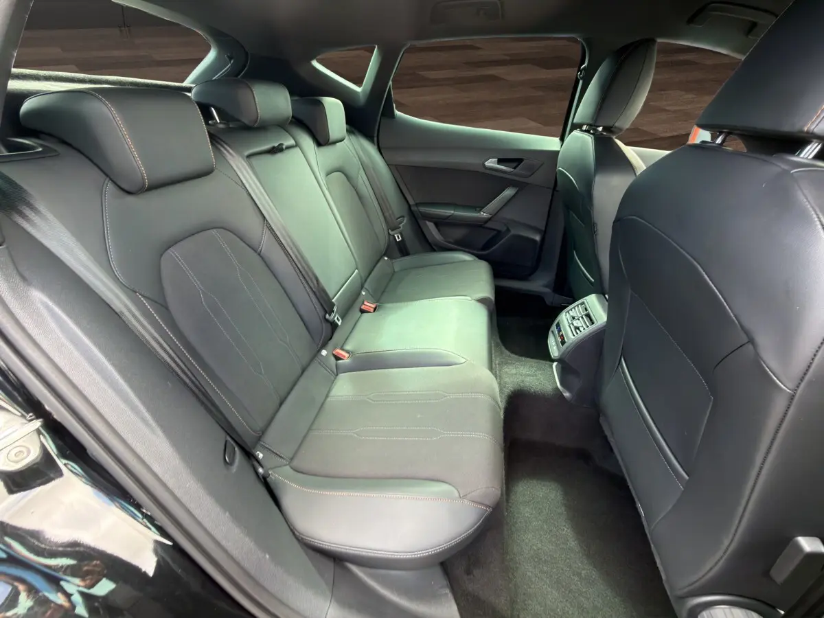 Vue intérieure arrière côté droit du CUPRA Formentor 2025 avec sièges noirs en cuir et tissu, finition soignée et console centrale.