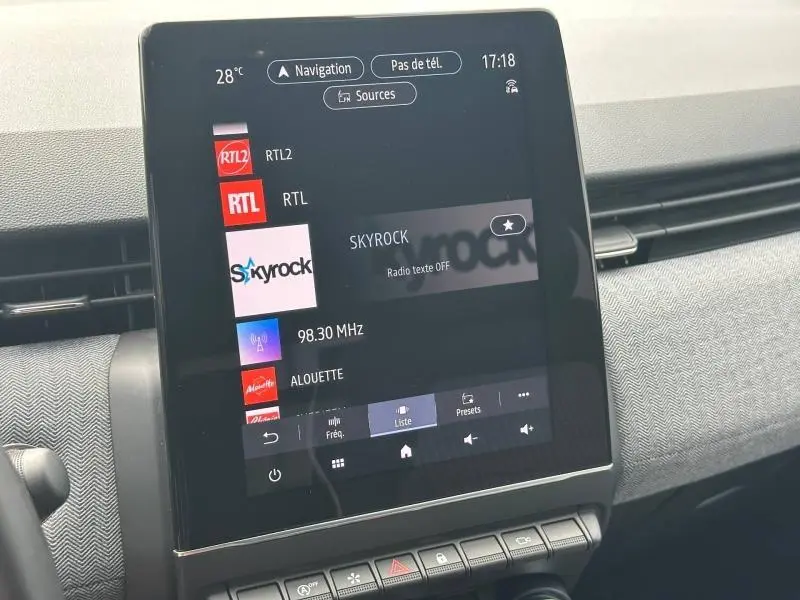 Écran tactile central de la Renault Clio 1.0 Eco-G 100ch Techno 2025 affichant les stations radio, intérieur gris et noir.