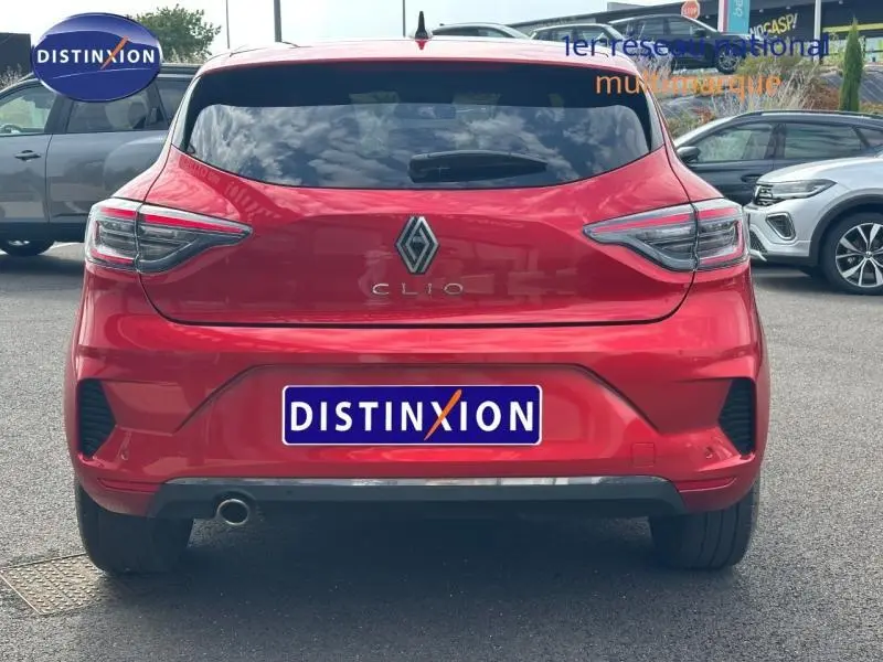 Vue arrière d'une Renault Clio rouge flamme 2025 avec feux LED et sortie d'échappement chromée visible.