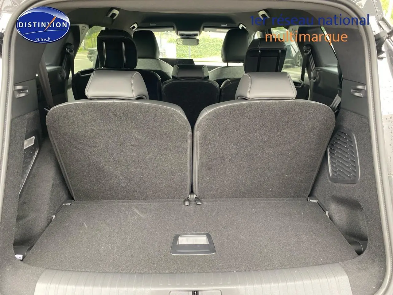 Vue du coffre arrière ouvert du Peugeot 5008 gris titane, montrant les sièges rang 3 relevés et l'intérieur spacieux.