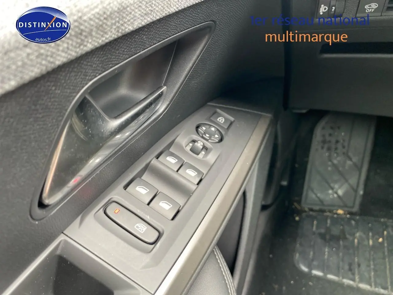 Gros plan sur les commandes des vitres électriques côté gauche d’un Peugeot 5008 gris titane, intérieur noir.