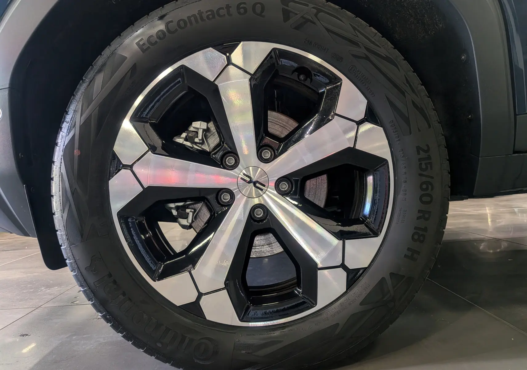 Gros plan sur la jante bi-ton noire et argentée du Dacia Bigster 2026 en Bleu Indigo, mettant en valeur le pneu Continental.