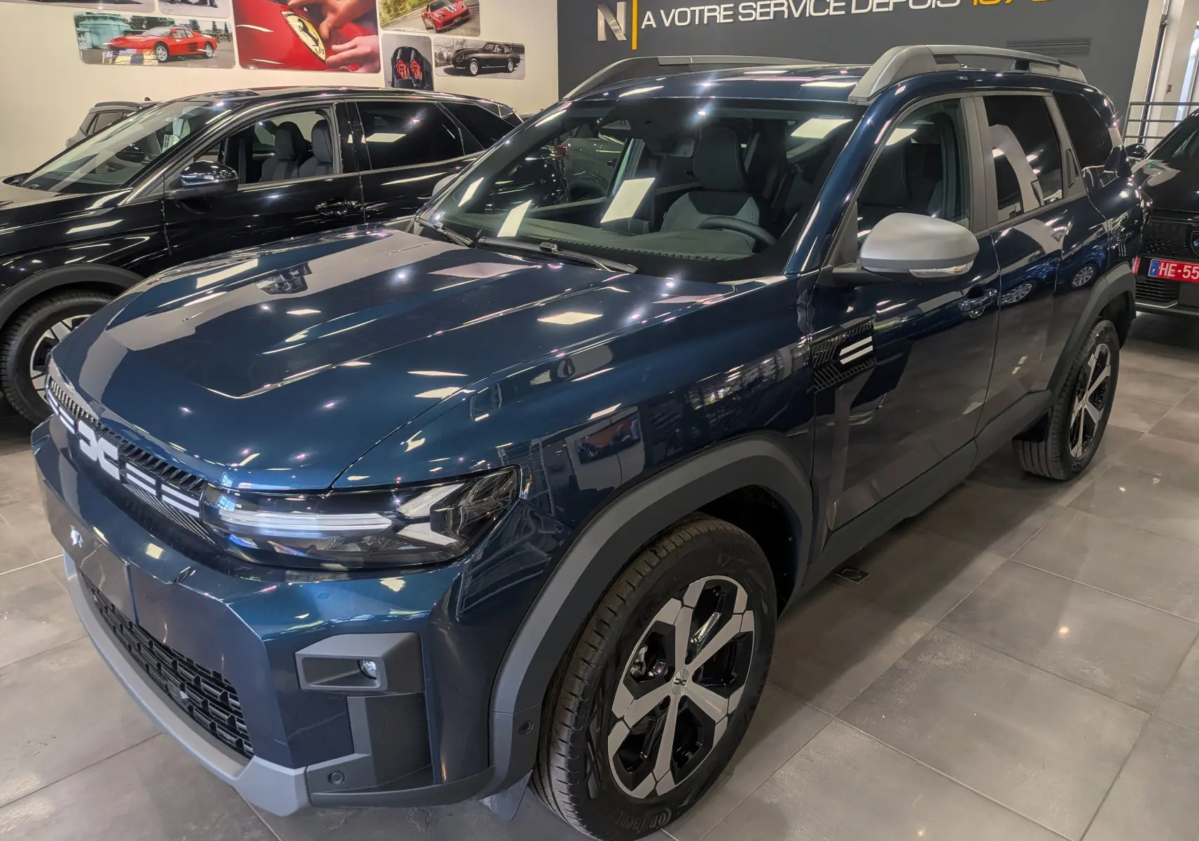 Dacia Bigster bleu indigo en vue 3/4 avant droit, avec jantes bicolores et détails noirs contrastants.