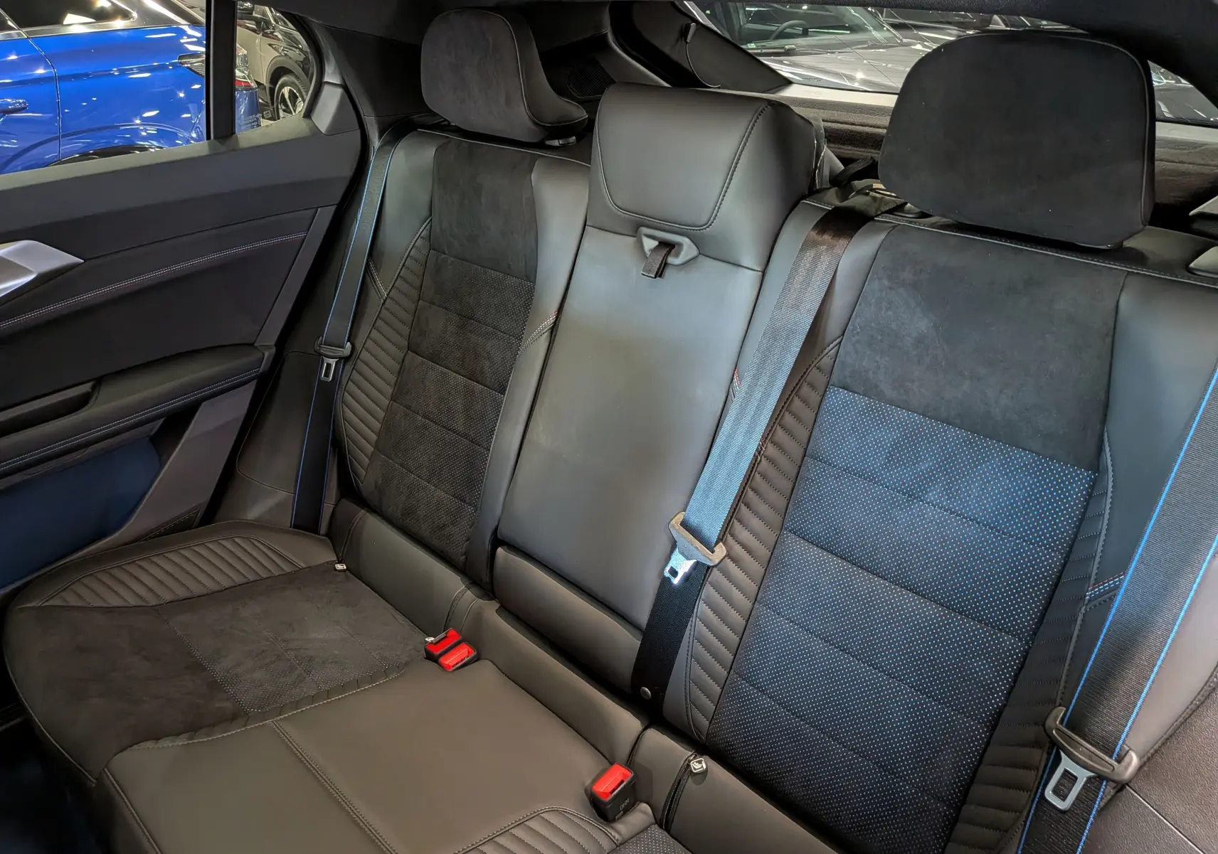 Vue intérieure arrière des sièges en cuir noir et alcantara avec surpiqûres bleues du Renault Rafale hyper hybrid 2026.