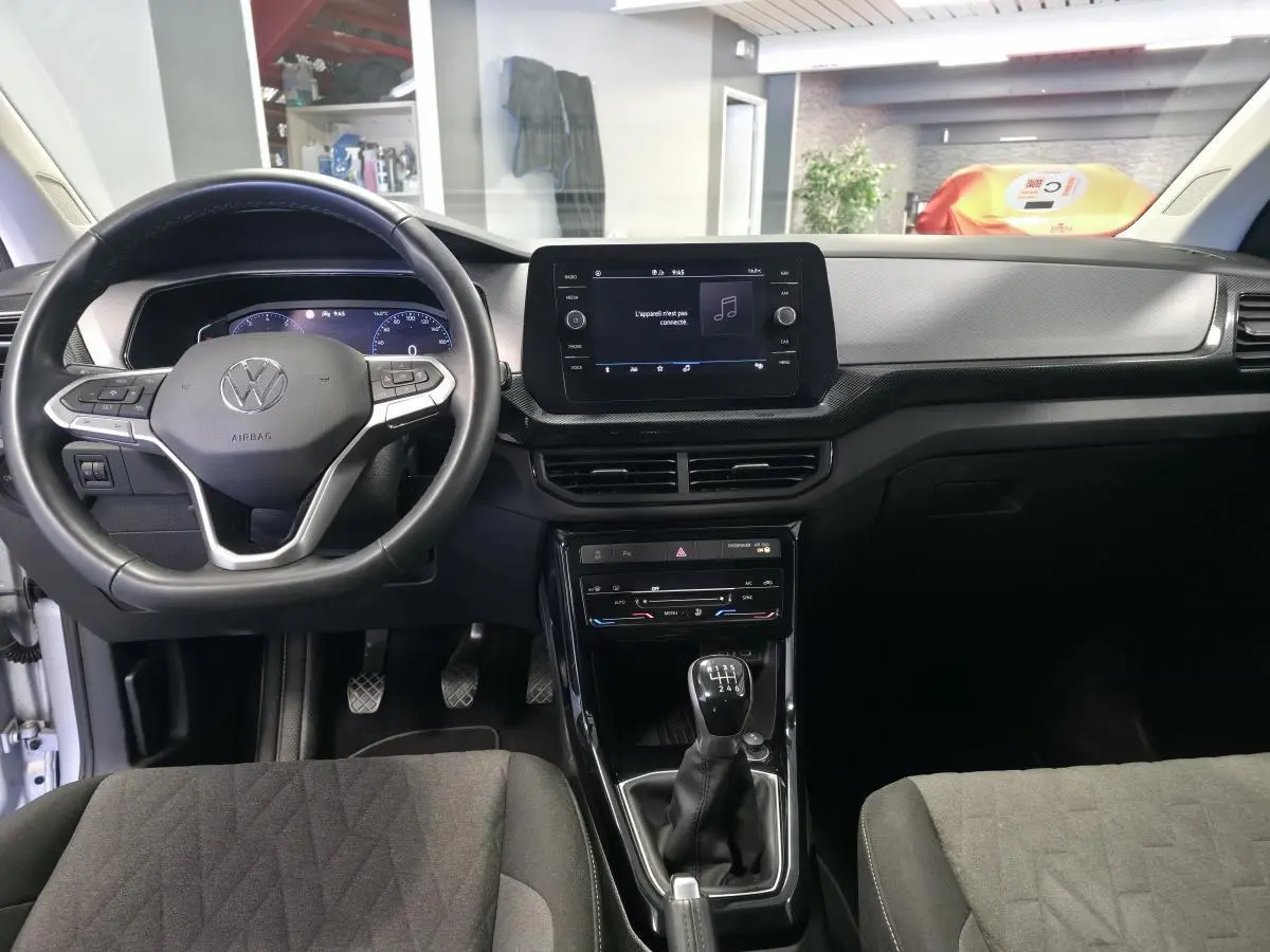 Vue intérieure frontale du Volkswagen T-Cross gris 2025, avec volant cuir multifonction et écran tactile central.