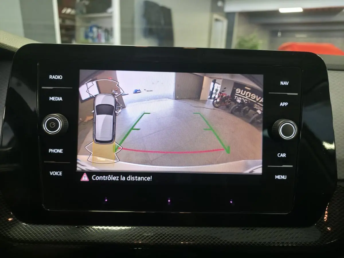Écran central affichant la caméra de recul du Volkswagen T-Cross gris, vue arrière avec guidage de trajectoire.