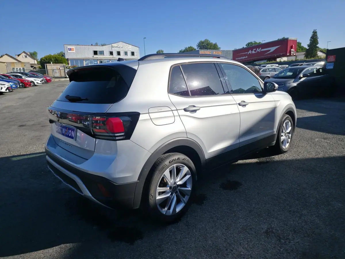 Volkswagen T-Cross gris métallisé vu en 3/4 arrière droit, avec jantes alliage 17 pouces et vitres teintées.
